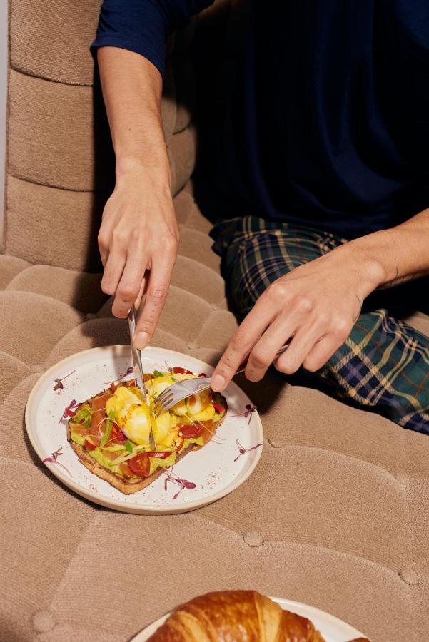 Sanderson Londra Exterior foto A person using a knife and fork to cut food